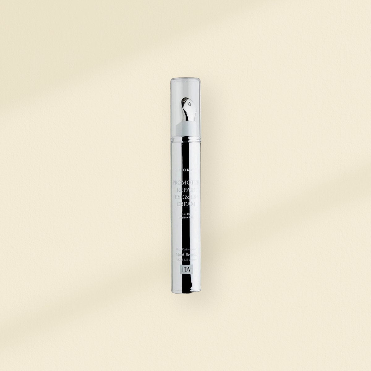 Eye and lip care: HOP+ Promoter Volumizing Eye and Lip Cream applicator on a warm plaster wall
