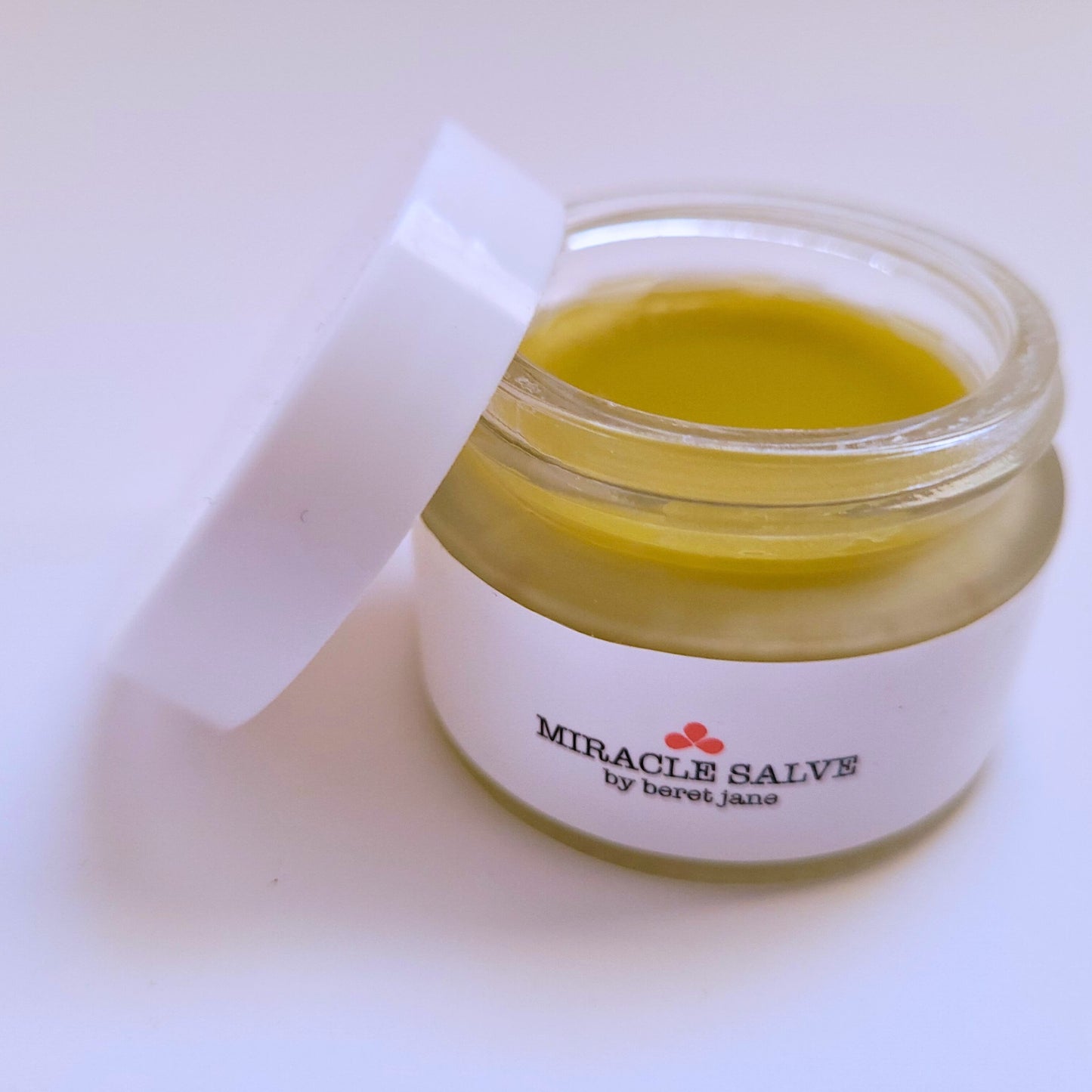 Open jar of Beret Jane Miracle Salve, regular .78 oz size, with the lid off